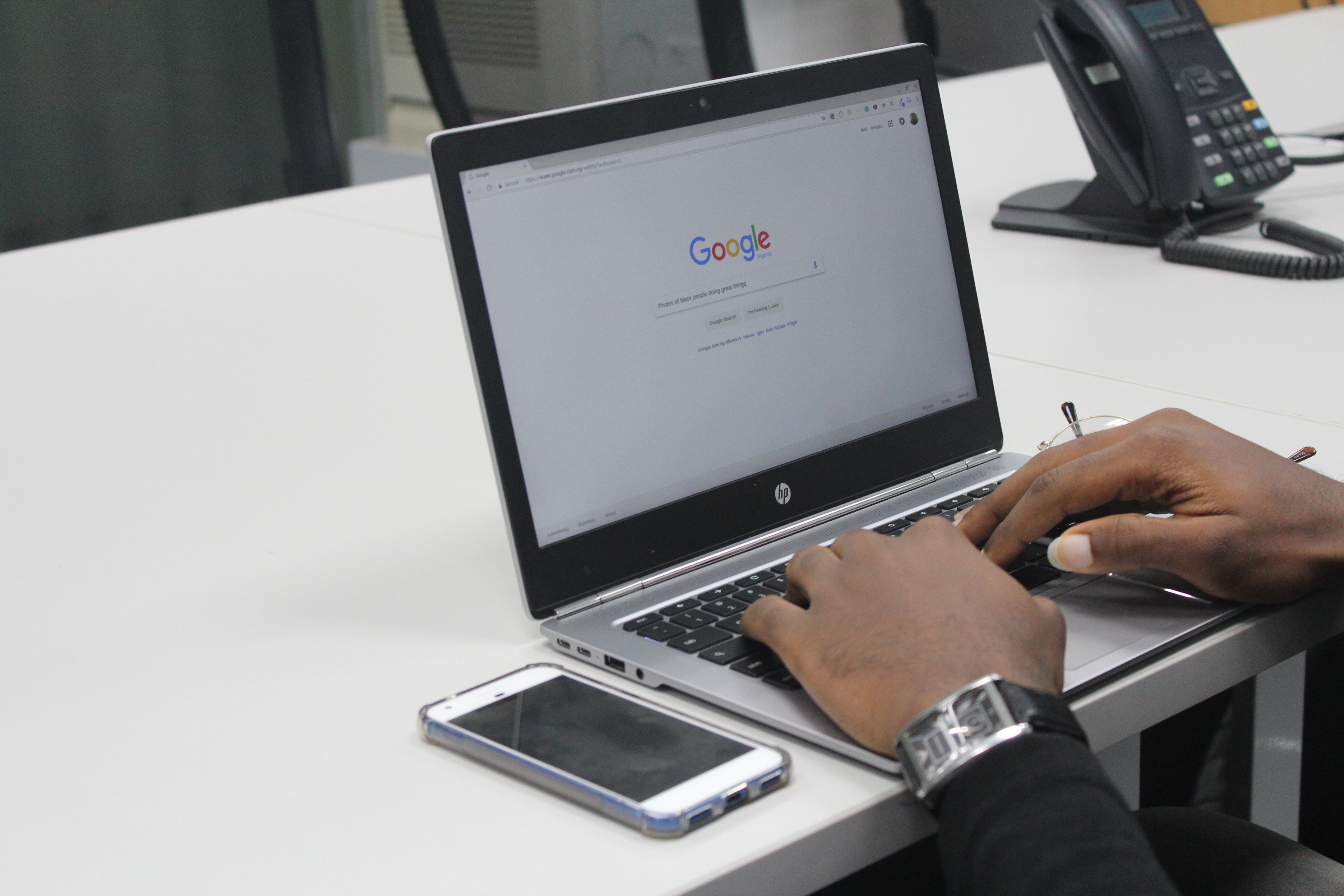 Laptop on desk with Google search page opened on screen.